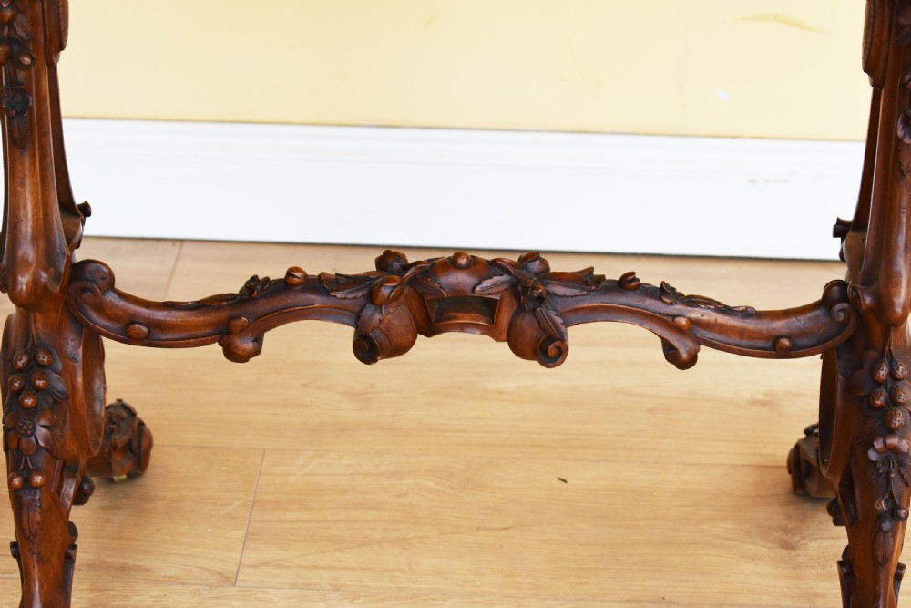A Victorian burr walnut occasional table featuring a serpentine top with wood inlay, supported by carved legs and a central stretcher. View II