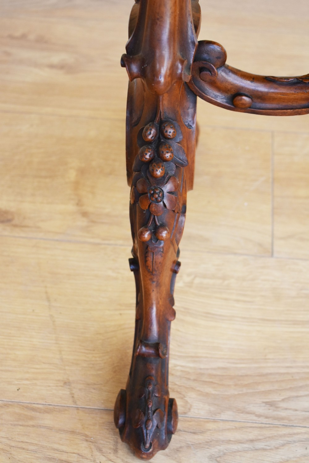 A Victorian burr walnut occasional table featuring a serpentine top with wood inlay, supported by carved legs and a central stretcher. View III