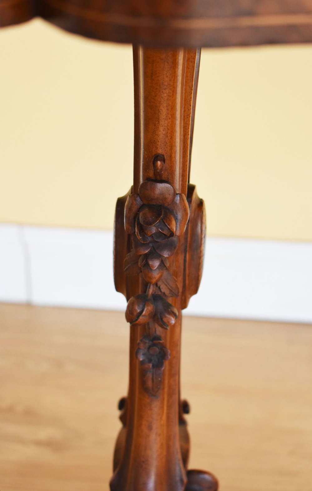A Victorian burr walnut occasional table featuring a serpentine top with wood inlay, supported by carved legs and a central stretcher. View IV