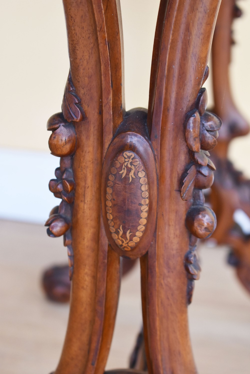 A Victorian burr walnut occasional table featuring a serpentine top with wood inlay, supported by carved legs and a central stretcher. View VII