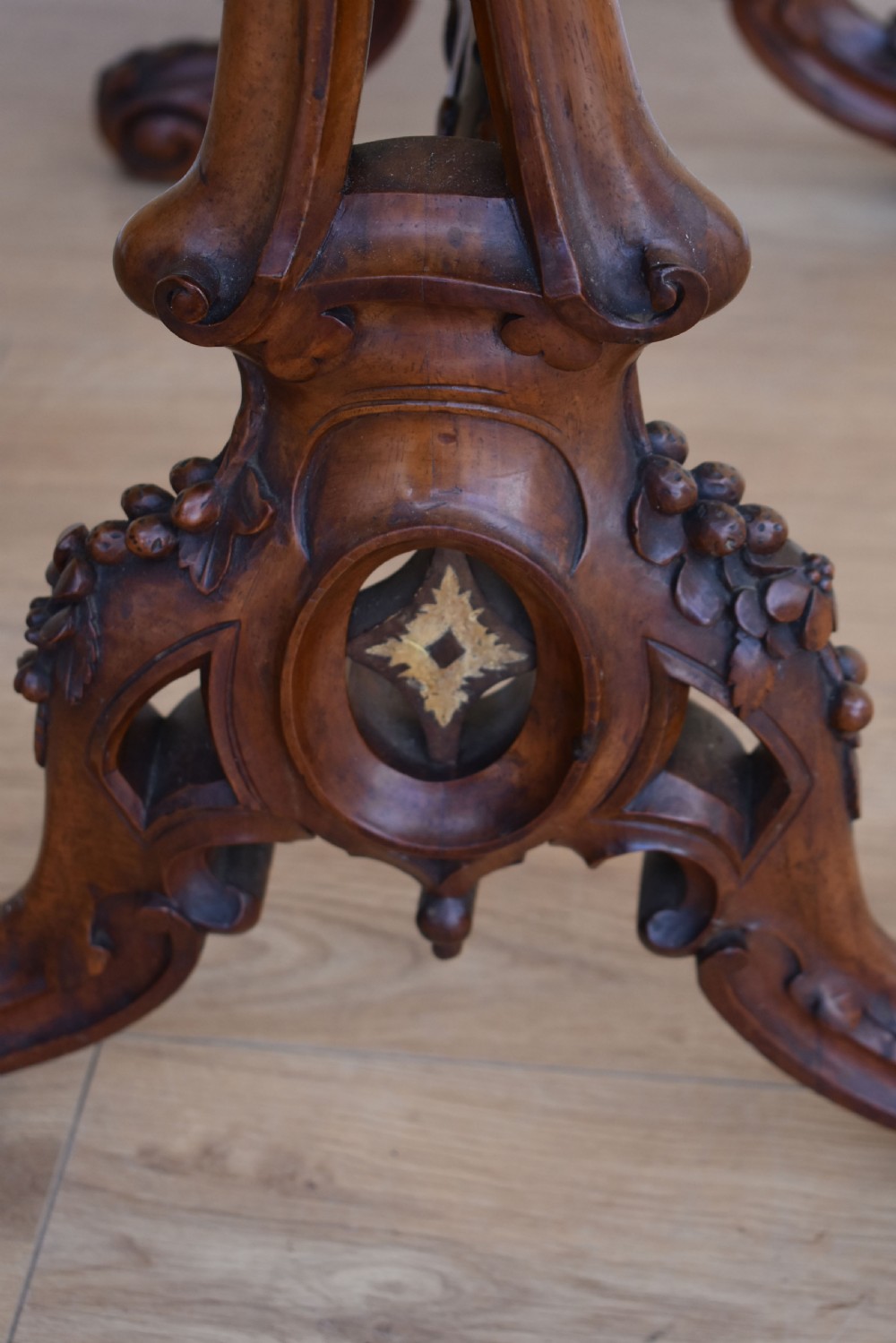 A Victorian burr walnut occasional table featuring a serpentine top with wood inlay, supported by carved legs and a central stretcher. View VIII
