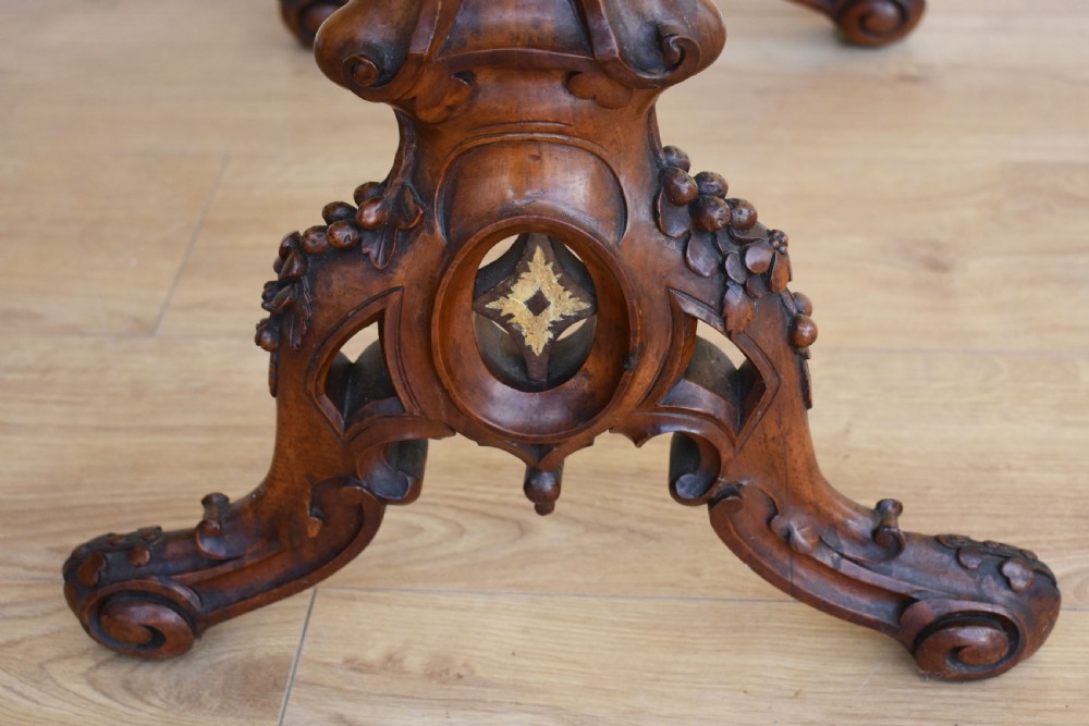 A Victorian burr walnut occasional table featuring a serpentine top with wood inlay, supported by carved legs and a central stretcher. View IX