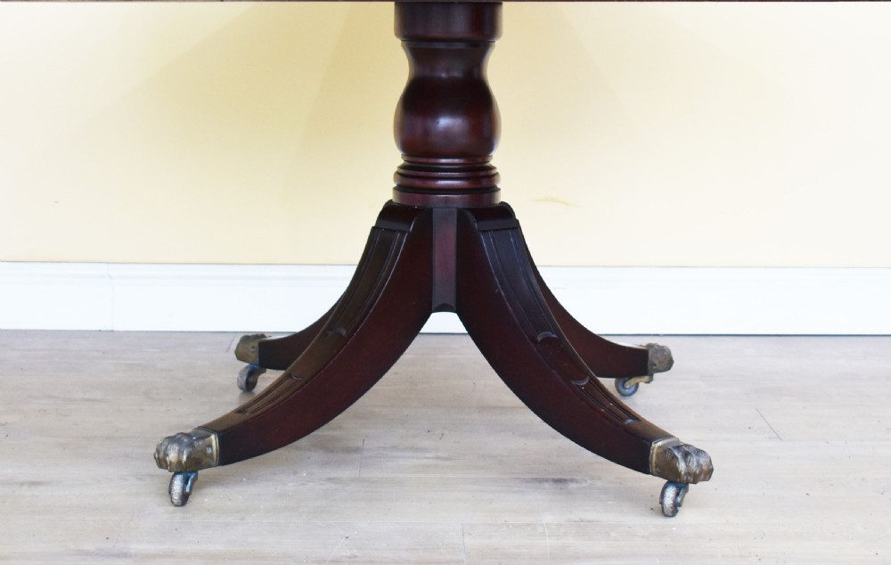 An octagonal Edwardian mahogany drum table featuring a leather inset top, drawers with brass handles, and a central pedestal with four splayed legs on brass castors. View II