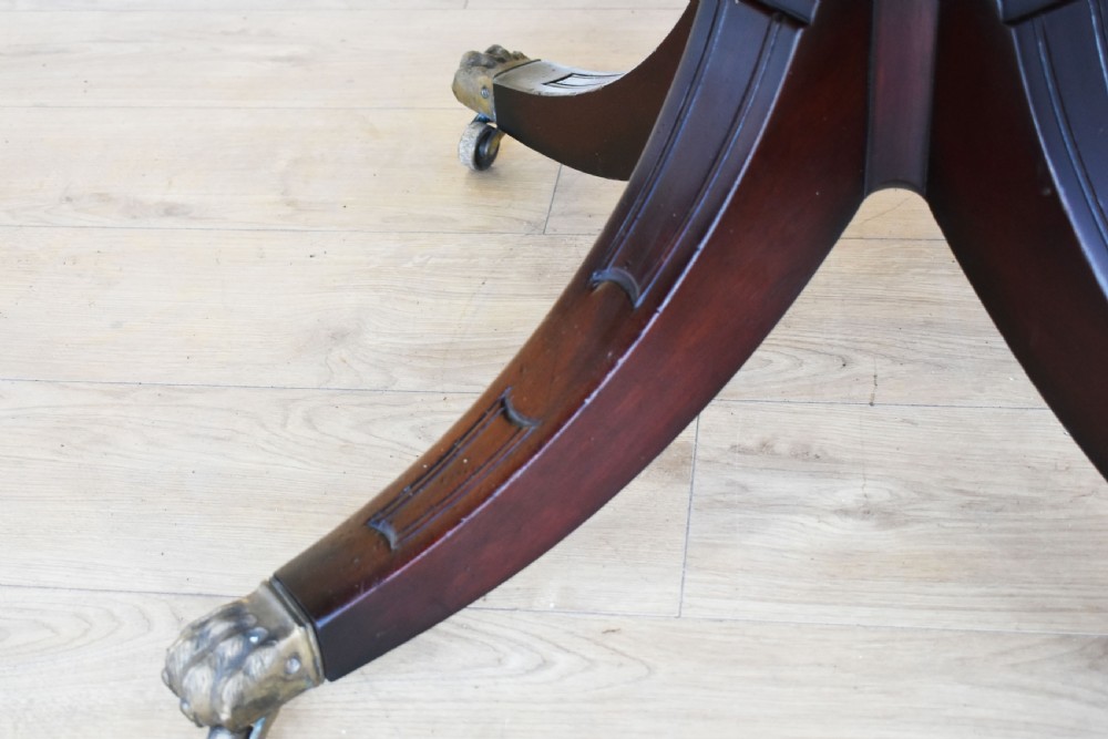 An octagonal Edwardian mahogany drum table featuring a leather inset top, drawers with brass handles, and a central pedestal with four splayed legs on brass castors. View IV