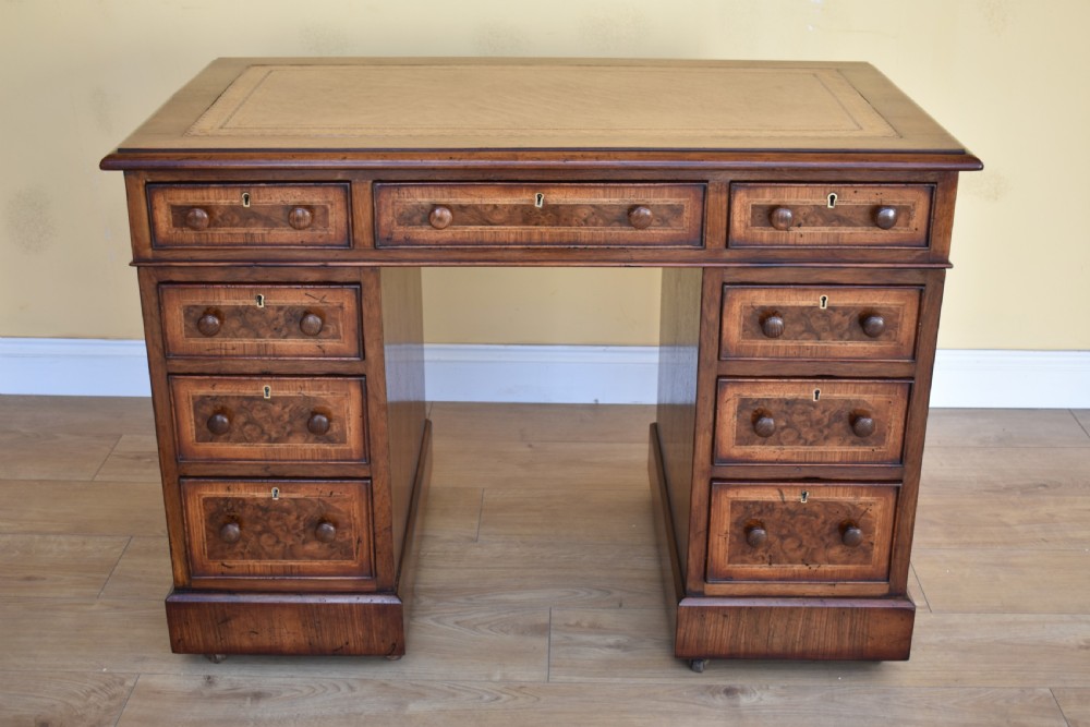 A nineteenth-century Victorian pedestal desk crafted from burr walnut featuring nine drawers with turned wooden handles and a leather writing top. View II