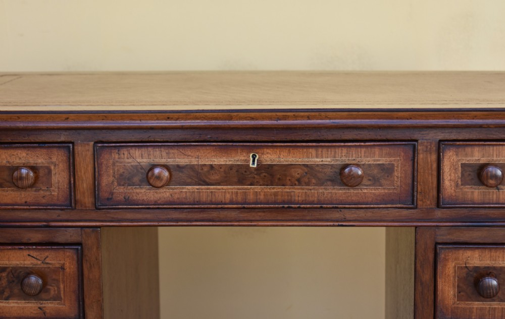 A nineteenth-century Victorian pedestal desk crafted from burr walnut featuring nine drawers with turned wooden handles and a leather writing top. View IV