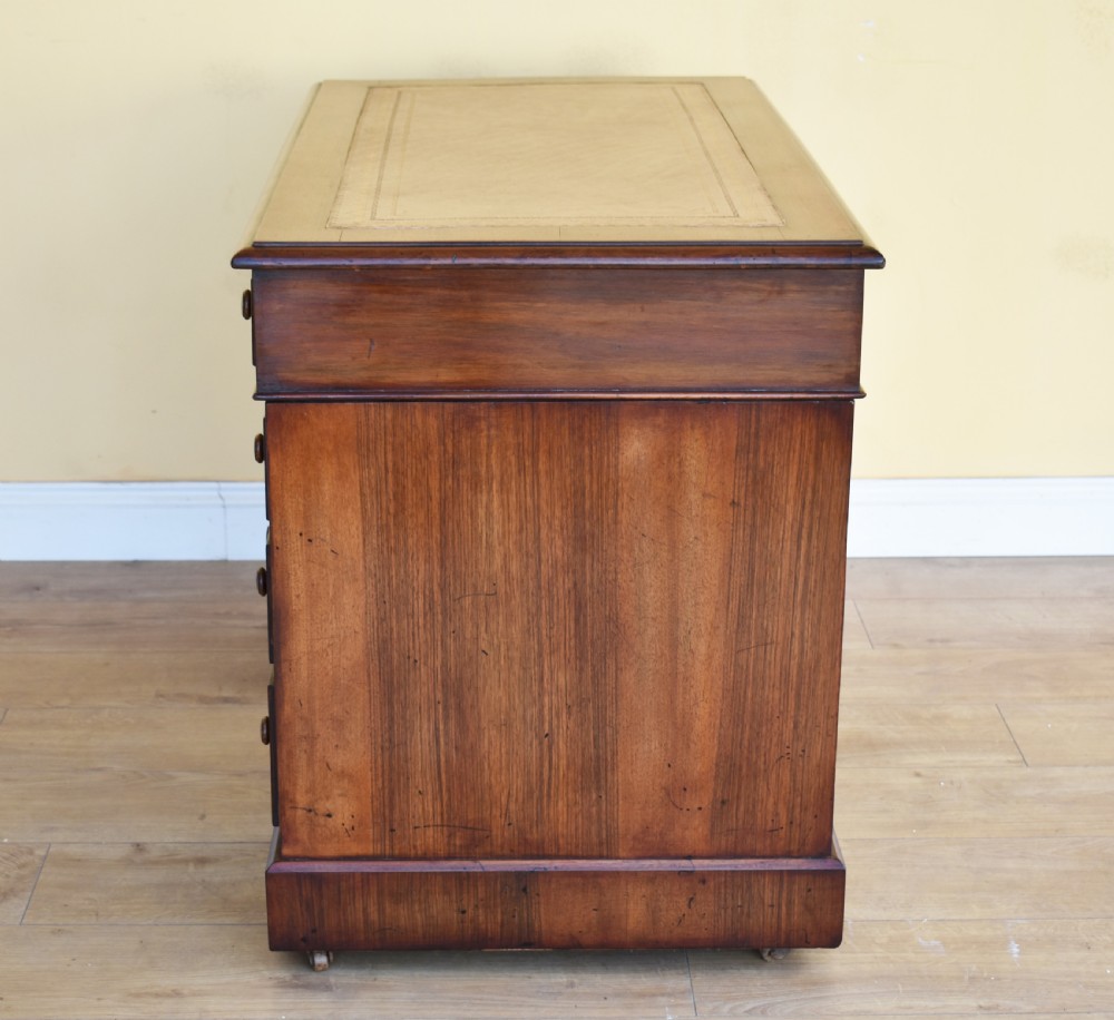 A nineteenth-century Victorian pedestal desk crafted from burr walnut featuring nine drawers with turned wooden handles and a leather writing top. View IX