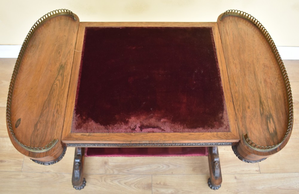 A 19th-century William IV rosewood writing table featuring an adjustable velvet-covered reading slope flanked by brass gallery rails on carved pedestal supports. View V