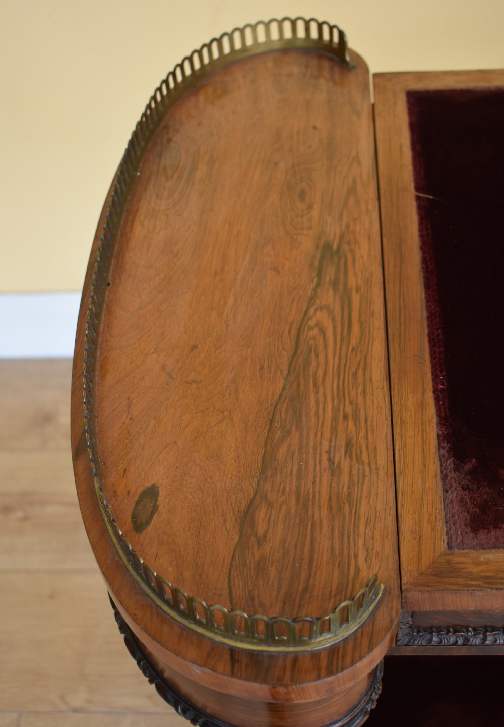 A 19th-century William IV rosewood writing table featuring an adjustable velvet-covered reading slope flanked by brass gallery rails on carved pedestal supports. View VI