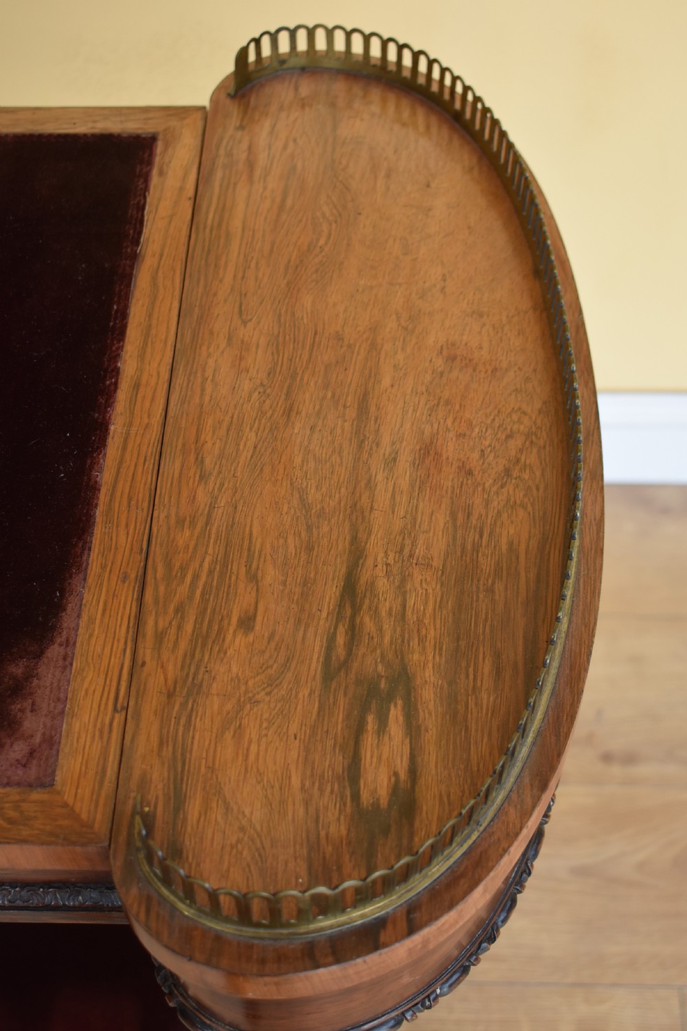 A 19th-century William IV rosewood writing table featuring an adjustable velvet-covered reading slope flanked by brass gallery rails on carved pedestal supports. View VII