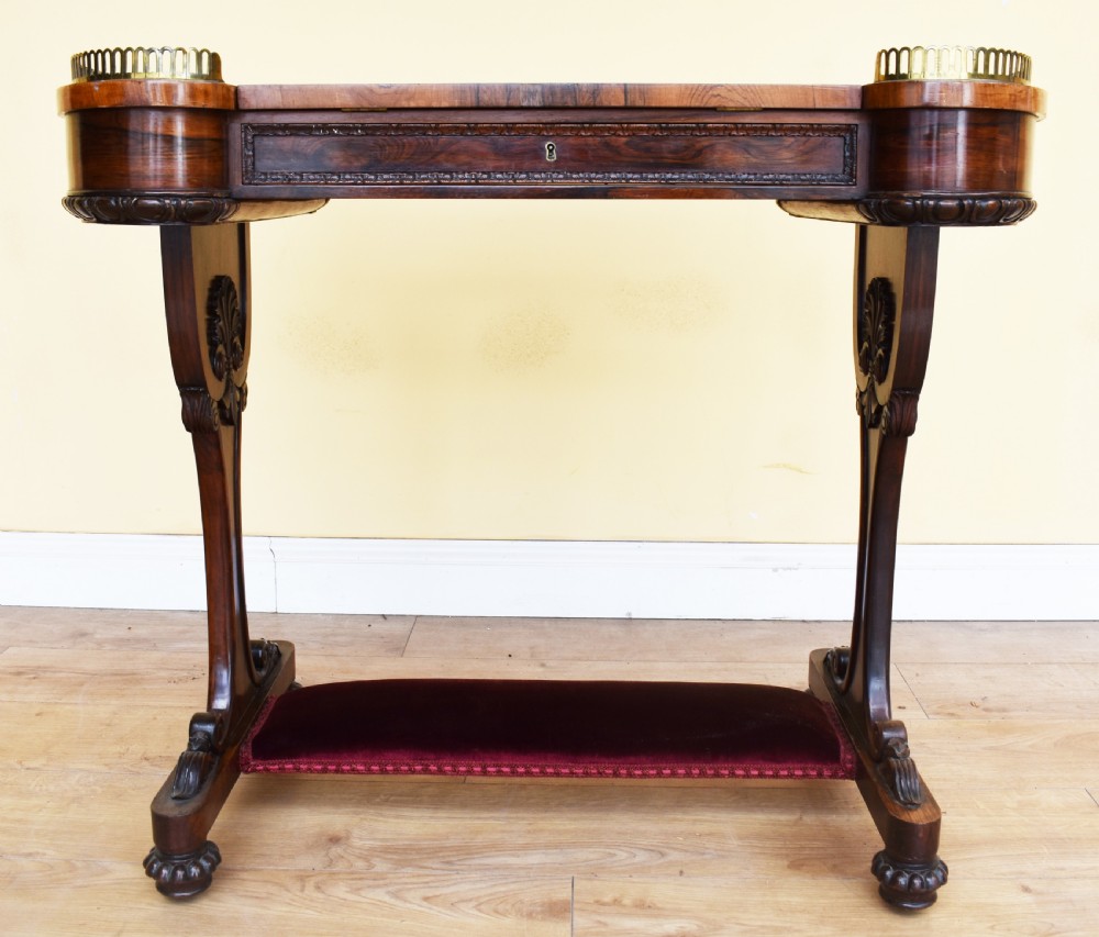 A 19th-century William IV rosewood writing table featuring an adjustable velvet-covered reading slope flanked by brass gallery rails on carved pedestal supports. View VIII
