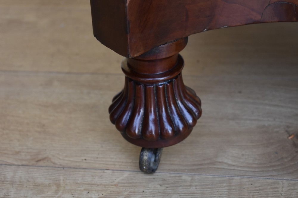 A 19th-century Regency mahogany extending dining table with twin octagonal pedestals, concave bases, reeded feet, and brass castors. View IV