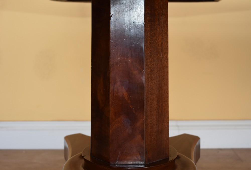 A 19th-century Regency mahogany extending dining table with twin octagonal pedestals, concave bases, reeded feet, and brass castors. View VI