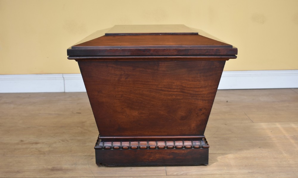 A 19th-century William IV sarcophagus-shaped mahogany wine cooler with a stepped lid and gadrooned plinth base. View IV