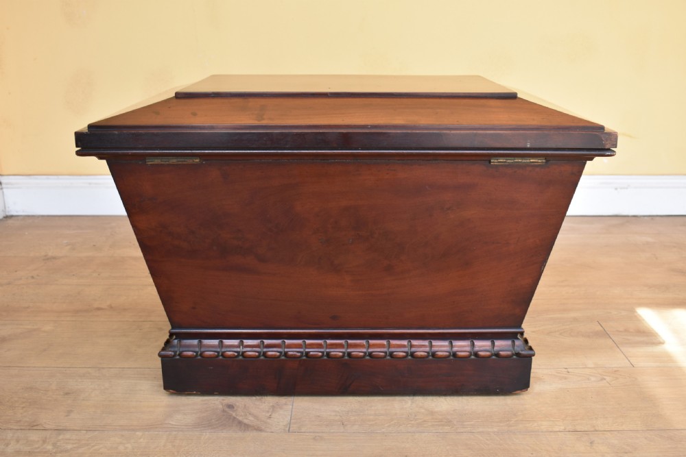 A 19th-century William IV sarcophagus-shaped mahogany wine cooler with a stepped lid and gadrooned plinth base. View V