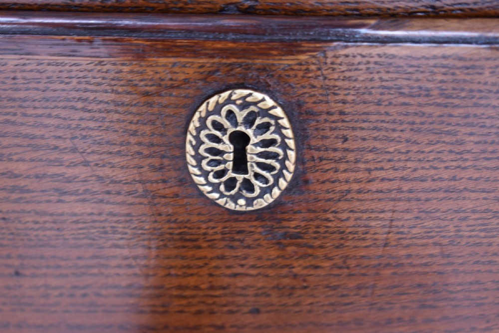 An 18th-century George III oak chest of drawers featuring a two over three drawer arrangement with brass handles and bracket feet. View VIII