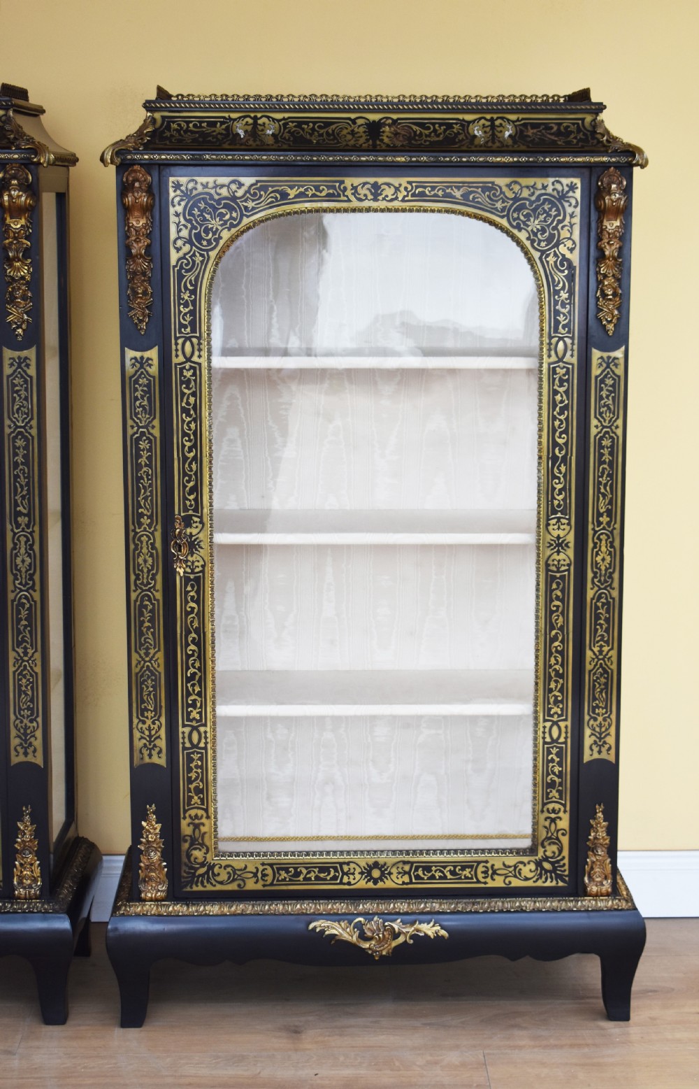 A pair of 19th-century ebonised display cabinets decorated with intricate brass Boulle marquetry, glazed arched doors, and gilt-bronze mounts. View III
