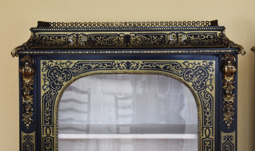 A pair of 19th-century ebonised display cabinets decorated with intricate brass Boulle marquetry, glazed arched doors, and gilt-bronze mounts. View IV