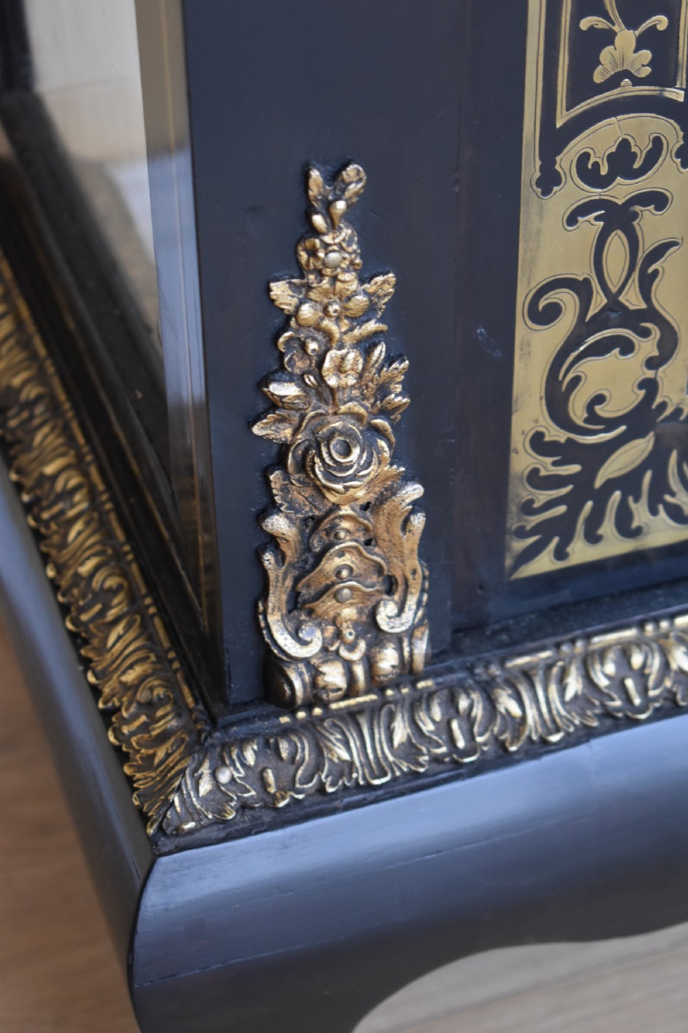 A pair of 19th-century ebonised display cabinets decorated with intricate brass Boulle marquetry, glazed arched doors, and gilt-bronze mounts. View V