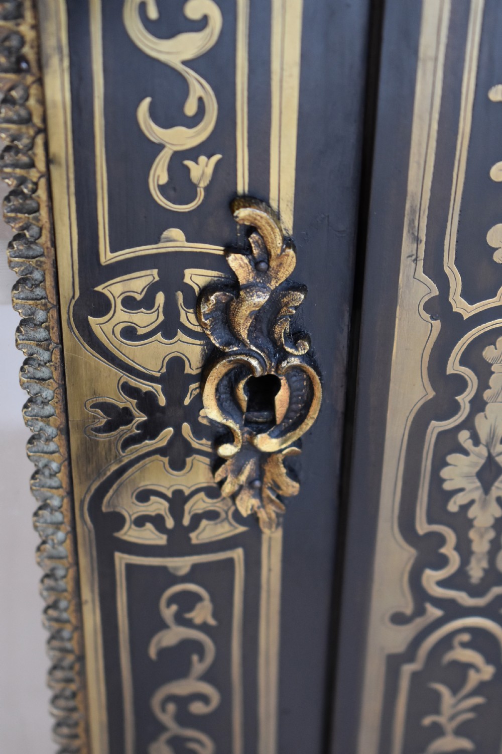 A pair of 19th-century ebonised display cabinets decorated with intricate brass Boulle marquetry, glazed arched doors, and gilt-bronze mounts. View VIII