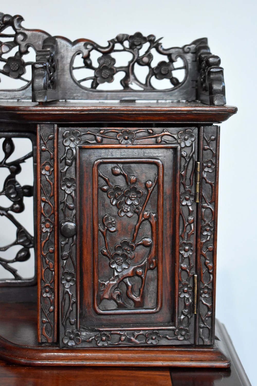 A 19th-century Chinese carved padouk wood desk featuring an intricate openwork gallery superstructure, frieze drawers, and cabriole legs ending in claw feet. View VI