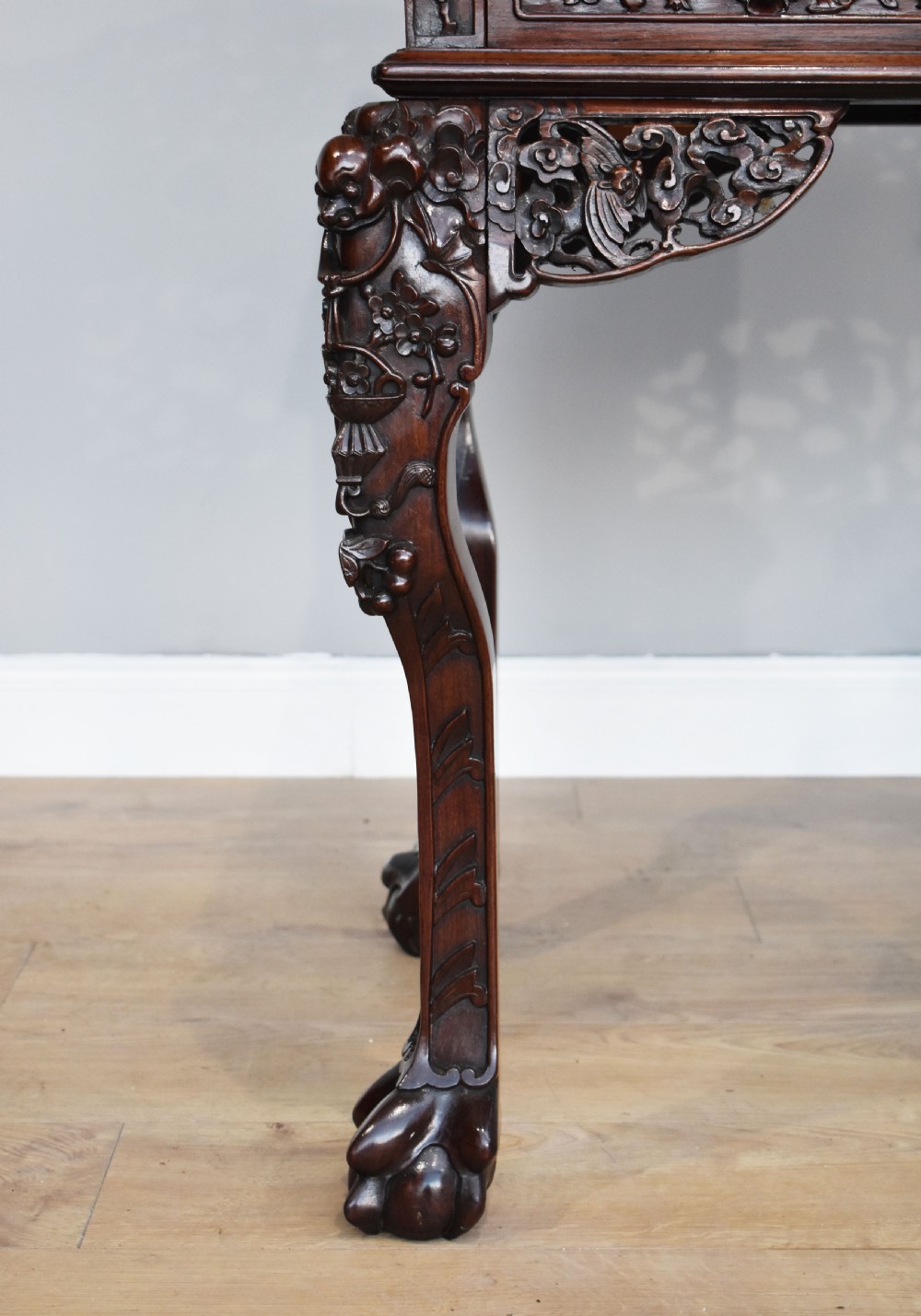 A 19th-century Chinese carved padouk wood desk featuring an intricate openwork gallery superstructure, frieze drawers, and cabriole legs ending in claw feet. View VII