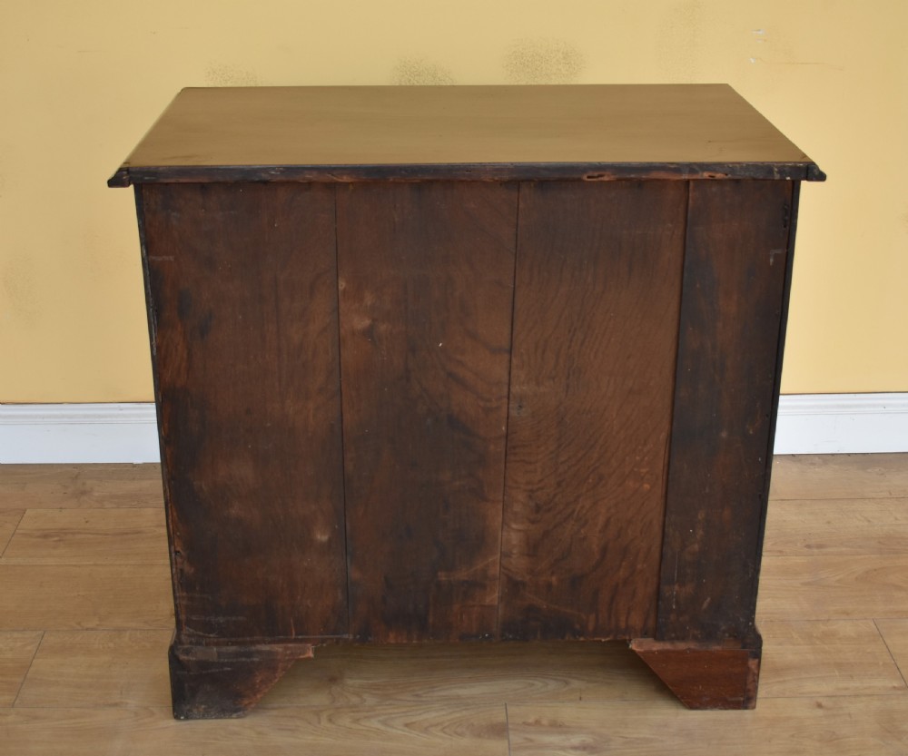 A George III mahogany chest of drawers featuring four graduated drawers, brass swan-neck handles, keyhole escutcheons, a brushing slide, and bracket feet. View VII