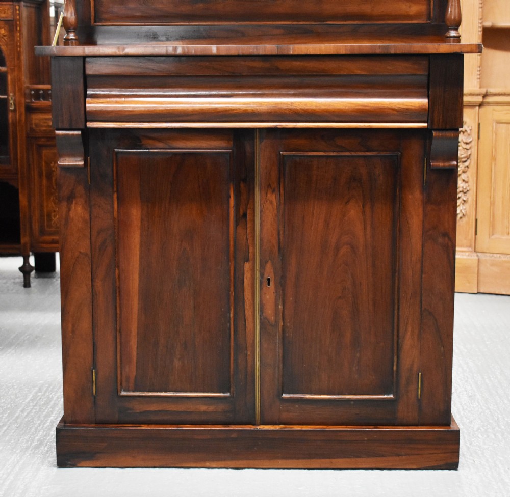 A Victorian rosewood chiffonier cabinet featuring twin panelled doors, a long frieze drawer, an upper gallery shelf with turned supports, and a solid plinth base. View III