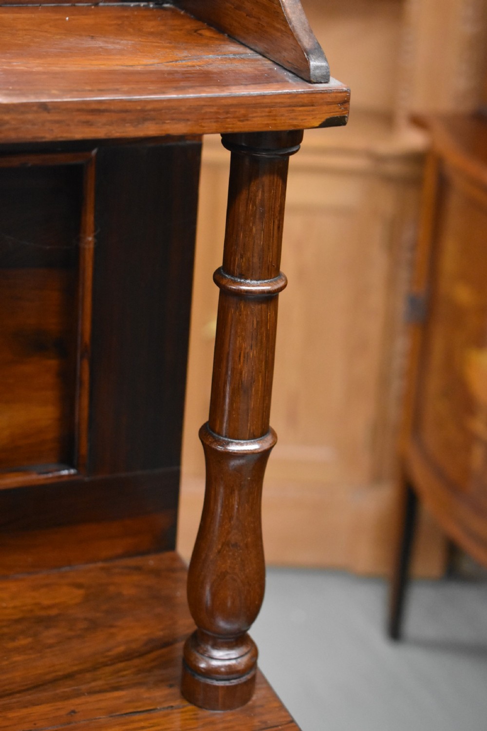 A Victorian rosewood chiffonier cabinet featuring twin panelled doors, a long frieze drawer, an upper gallery shelf with turned supports, and a solid plinth base. View IV