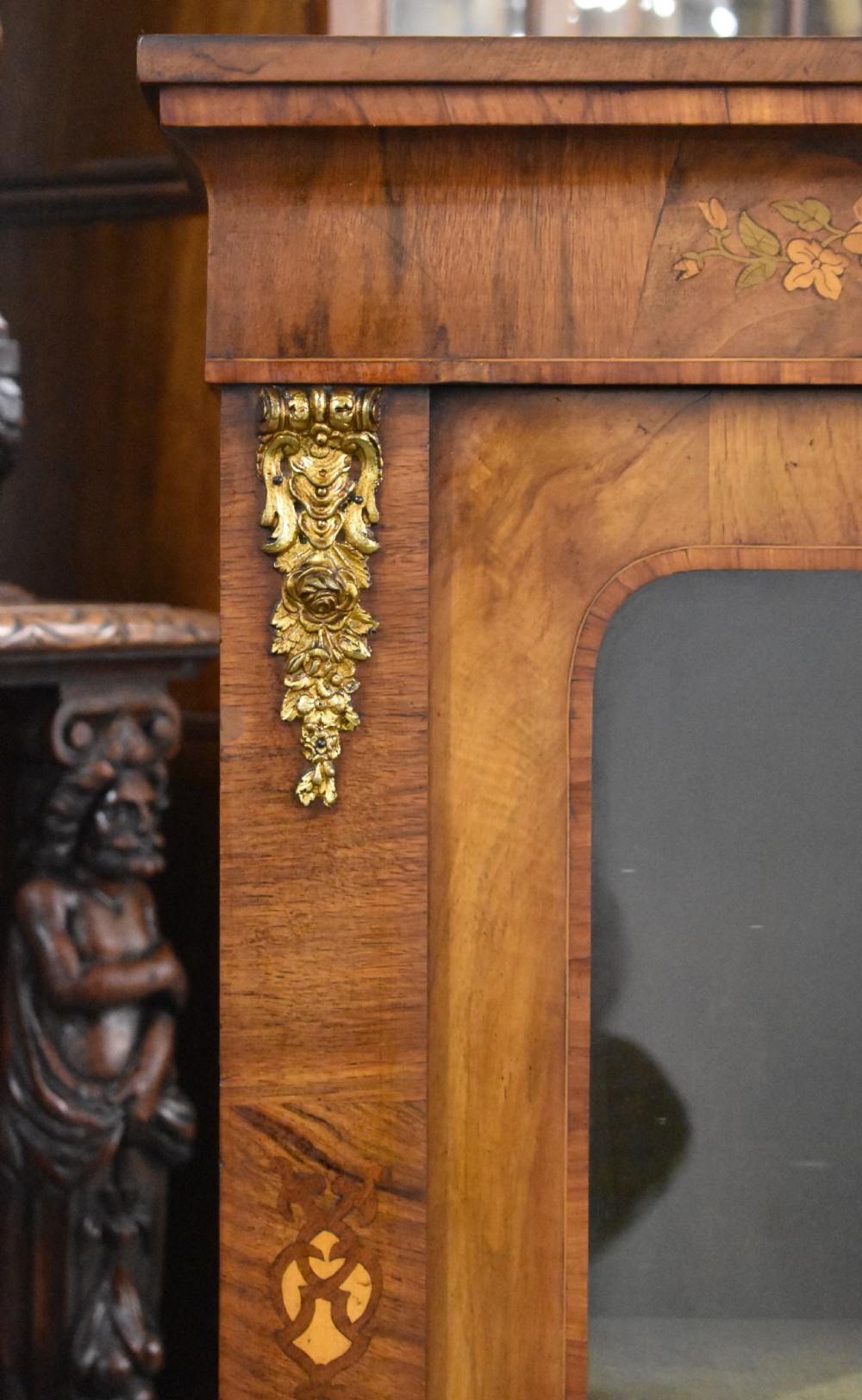 A Victorian walnut pier cabinet with a single glazed door, floral marquetry inlay, and gilt ormolu mounts. View V