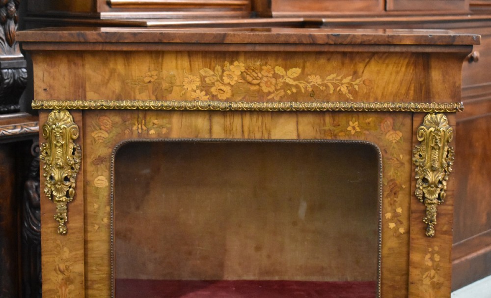 A Victorian walnut pier cabinet featuring floral marquetry inlays, decorative gilt ormolu mounts, and a glass door opening to velvet-lined shelves. View III