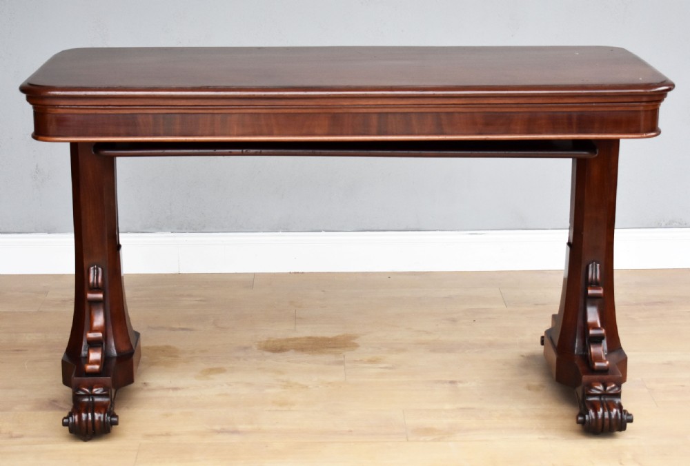 A Victorian mahogany telescopic dumbwaiter with a rectangular top, flame mahogany apron, and carved trestle feet. View II