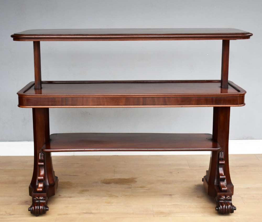A Victorian mahogany telescopic dumbwaiter with a rectangular top, flame mahogany apron, and carved trestle feet. View IV