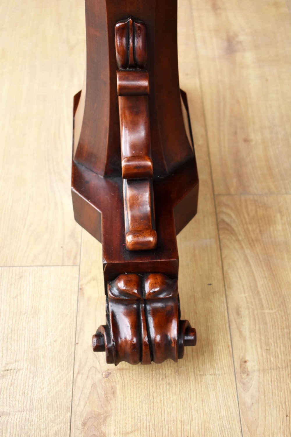 A Victorian mahogany telescopic dumbwaiter with a rectangular top, flame mahogany apron, and carved trestle feet. View VII