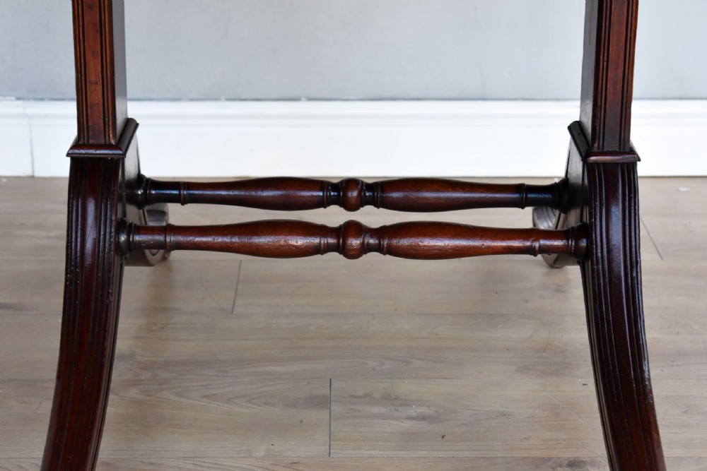 A Regency mahogany Pembroke table featuring drop-leaf sides, a front drawer with brass knobs, reeded splayed legs, and brass castors. View IV