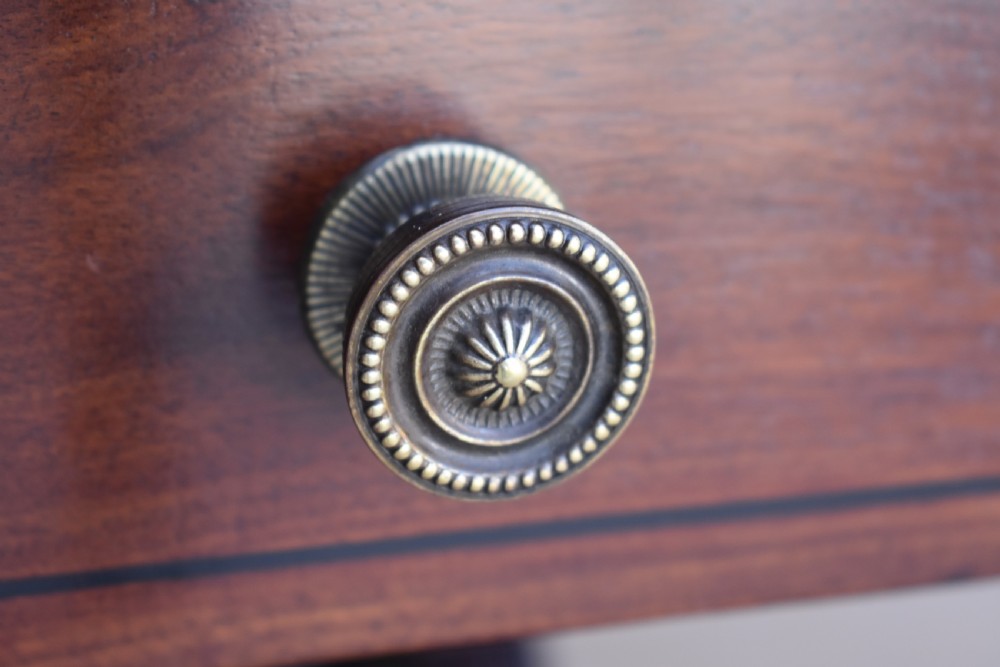 A Regency mahogany Pembroke table featuring drop-leaf sides, a front drawer with brass knobs, reeded splayed legs, and brass castors. View VIII