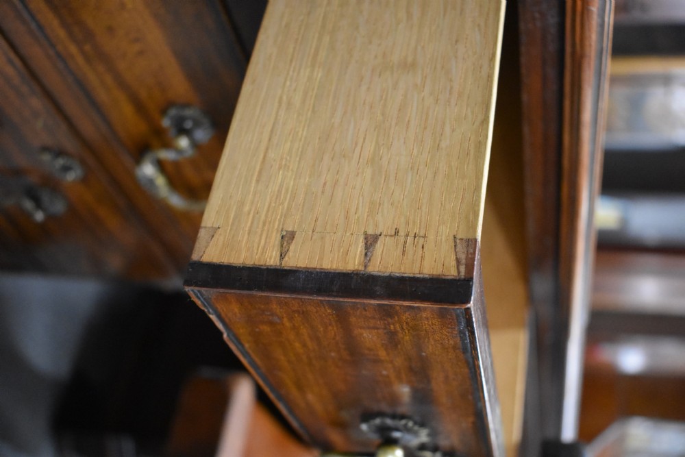 A 19th-century Chippendale style mahogany pedestal desk with a three-section leather inset top, nine drawers, brass handles, and carved pilasters. View XV