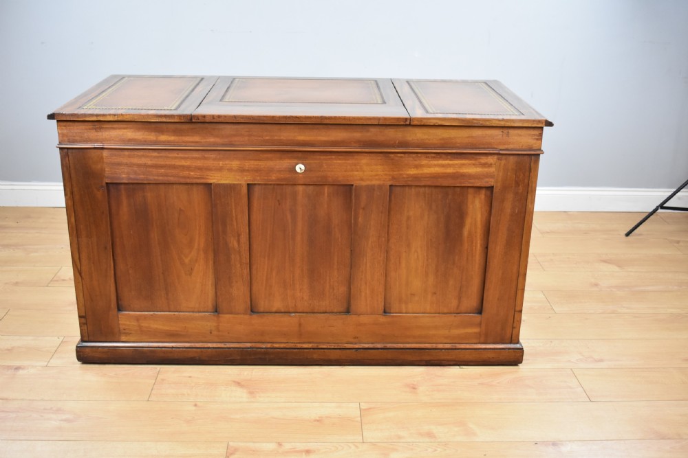 A Victorian mahogany kneehole desk with three leather-inlaid writing panels, twin pedestals featuring arched mouldings, and brass handles. View IX