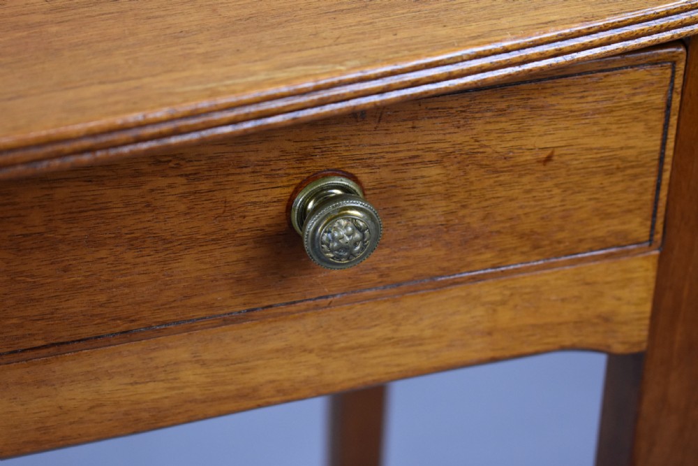 A 19th-century mahogany side table featuring a single drawer with brass knobs and tall, square tapered legs. View VII