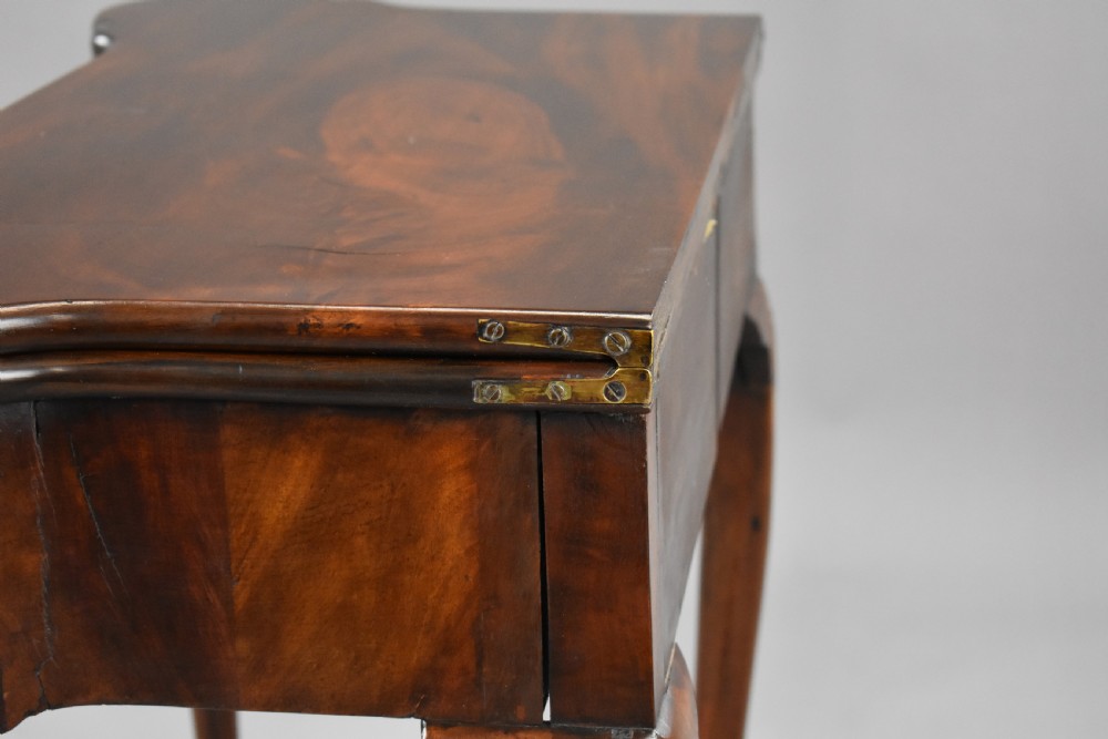 An 18th-century George II Irish mahogany fold-over card table with carved shell knees, a scalloped apron, and slender cabriole legs. View XVII