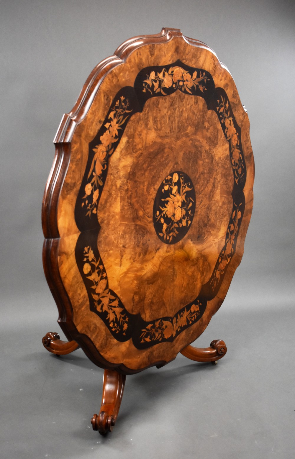 A Victorian burr walnut tilt-top breakfast table featuring a scalloped edge, intricate floral marquetry inlay border, and a carved four-star pedestal base. View II