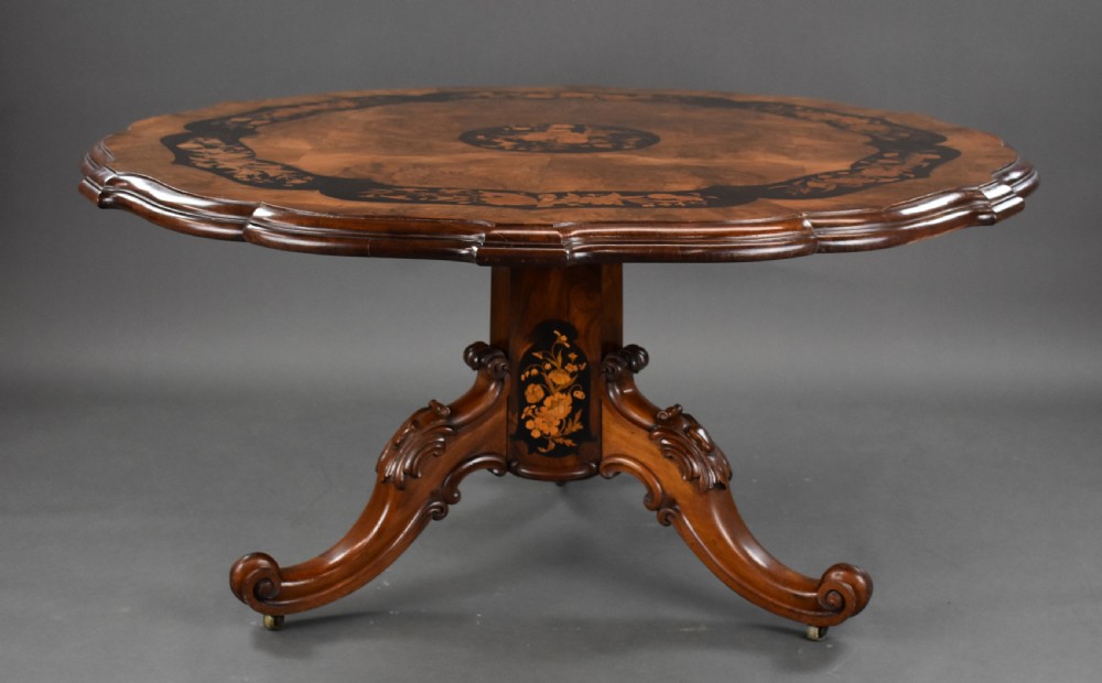 A Victorian burr walnut tilt-top breakfast table featuring a scalloped edge, intricate floral marquetry inlay border, and a carved four-star pedestal base. View III