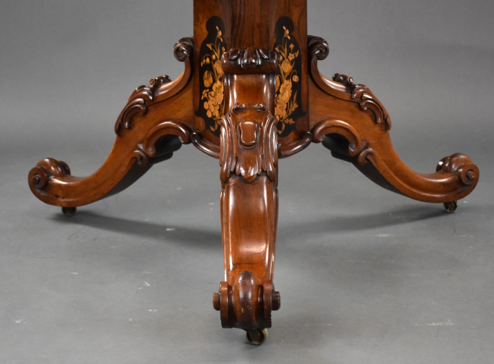 A Victorian burr walnut tilt-top breakfast table featuring a scalloped edge, intricate floral marquetry inlay border, and a carved four-star pedestal base. View XIV