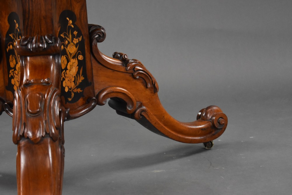 A Victorian burr walnut tilt-top breakfast table featuring a scalloped edge, intricate floral marquetry inlay border, and a carved four-star pedestal base. View XVI