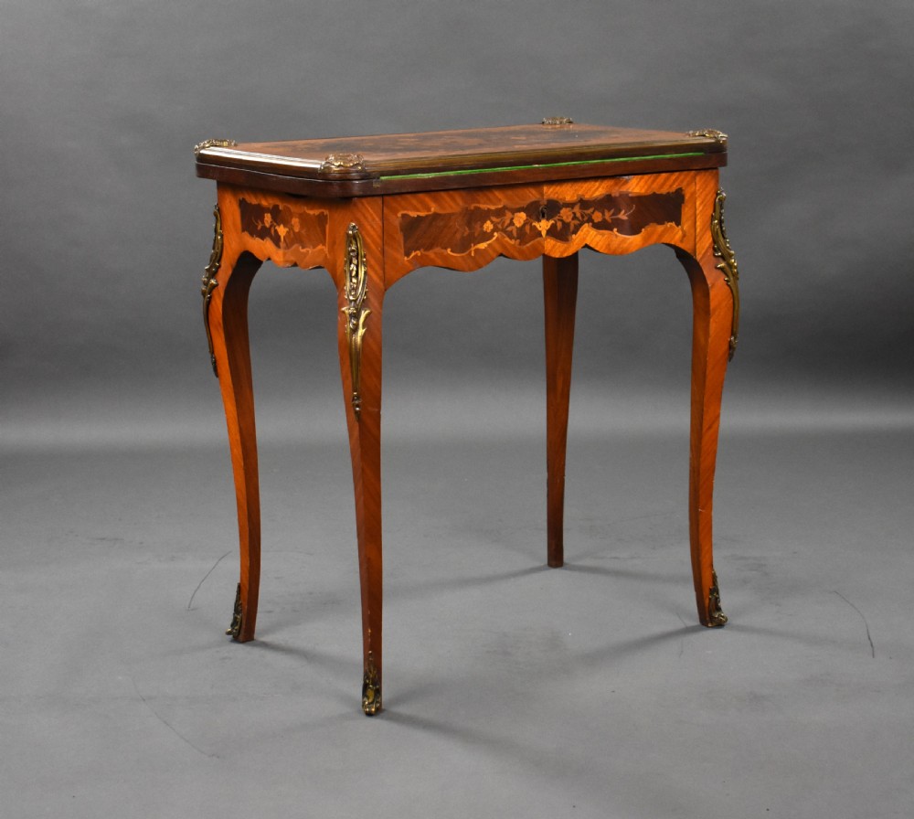 A Victorian French-style marquetry card table featuring slender cabriole legs with brass mounts and intricate floral inlay along the serpentine apron. View II