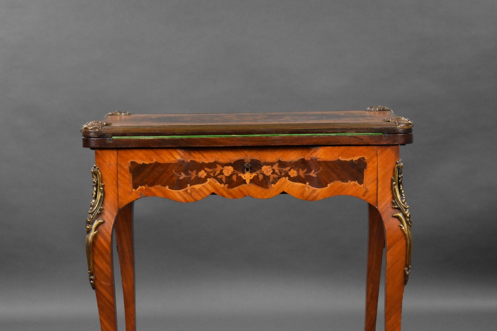 A Victorian French-style marquetry card table featuring slender cabriole legs with brass mounts and intricate floral inlay along the serpentine apron. View IV