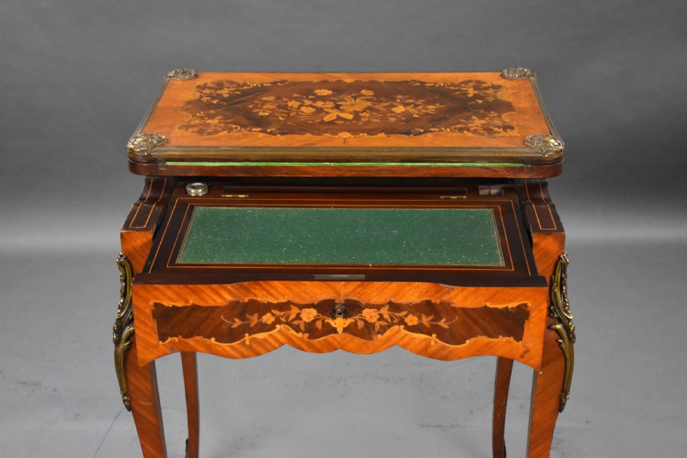 A Victorian French-style marquetry card table featuring slender cabriole legs with brass mounts and intricate floral inlay along the serpentine apron. View VI