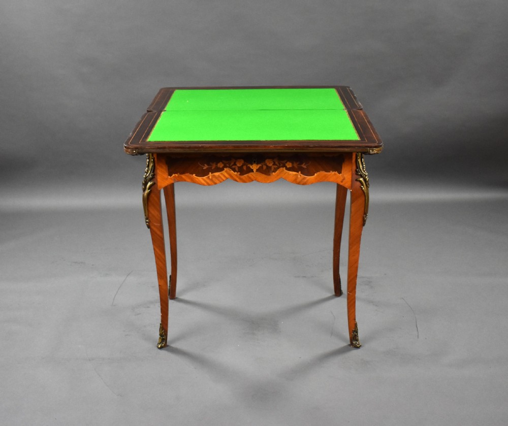A Victorian French-style marquetry card table featuring slender cabriole legs with brass mounts and intricate floral inlay along the serpentine apron. View VIII