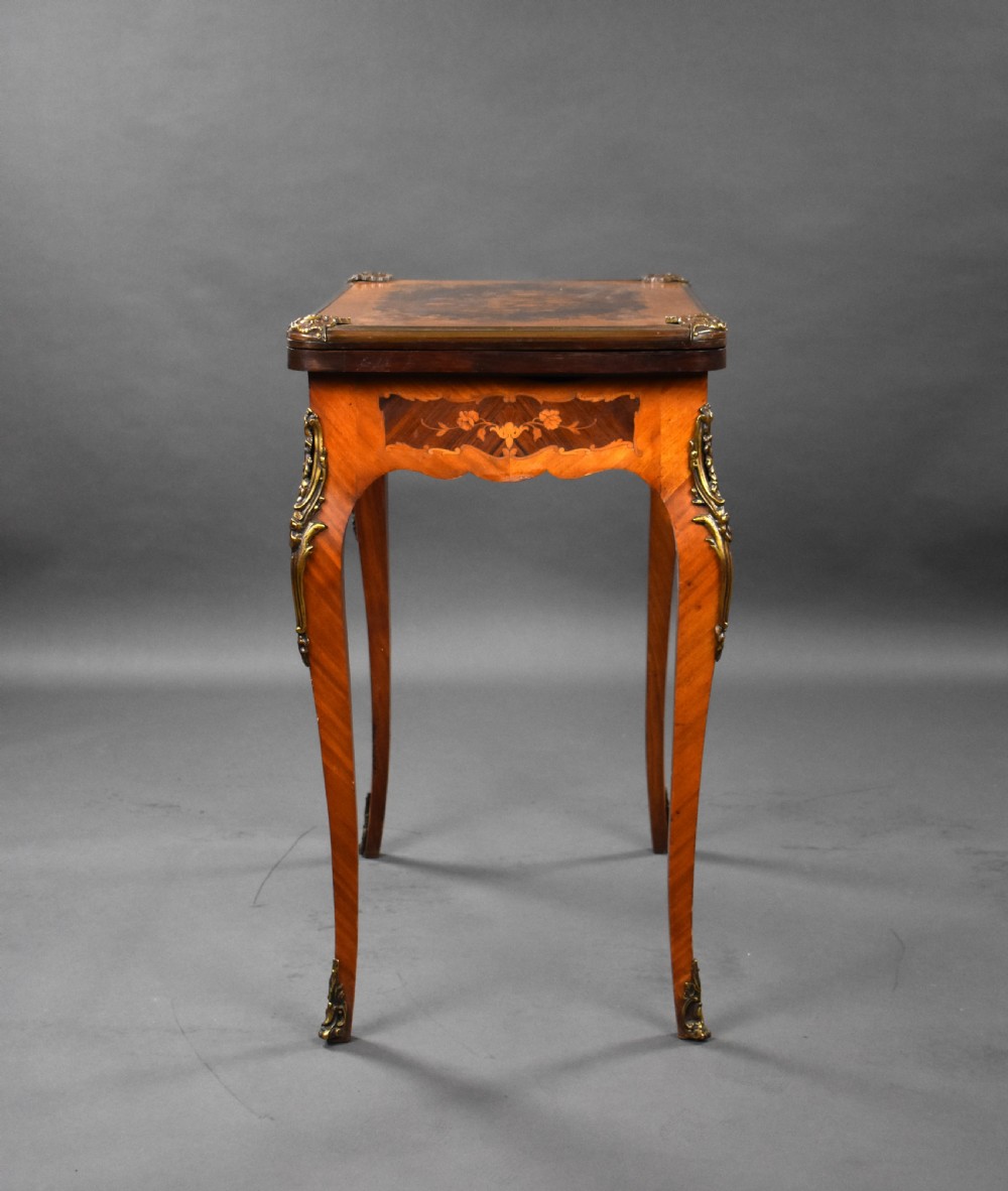 A Victorian French-style marquetry card table featuring slender cabriole legs with brass mounts and intricate floral inlay along the serpentine apron. View X
