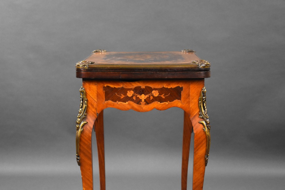 A Victorian French-style marquetry card table featuring slender cabriole legs with brass mounts and intricate floral inlay along the serpentine apron. View XV